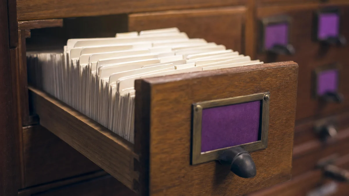 Close-up of a library card-index drawer pulled open showing dense rows of white tabs